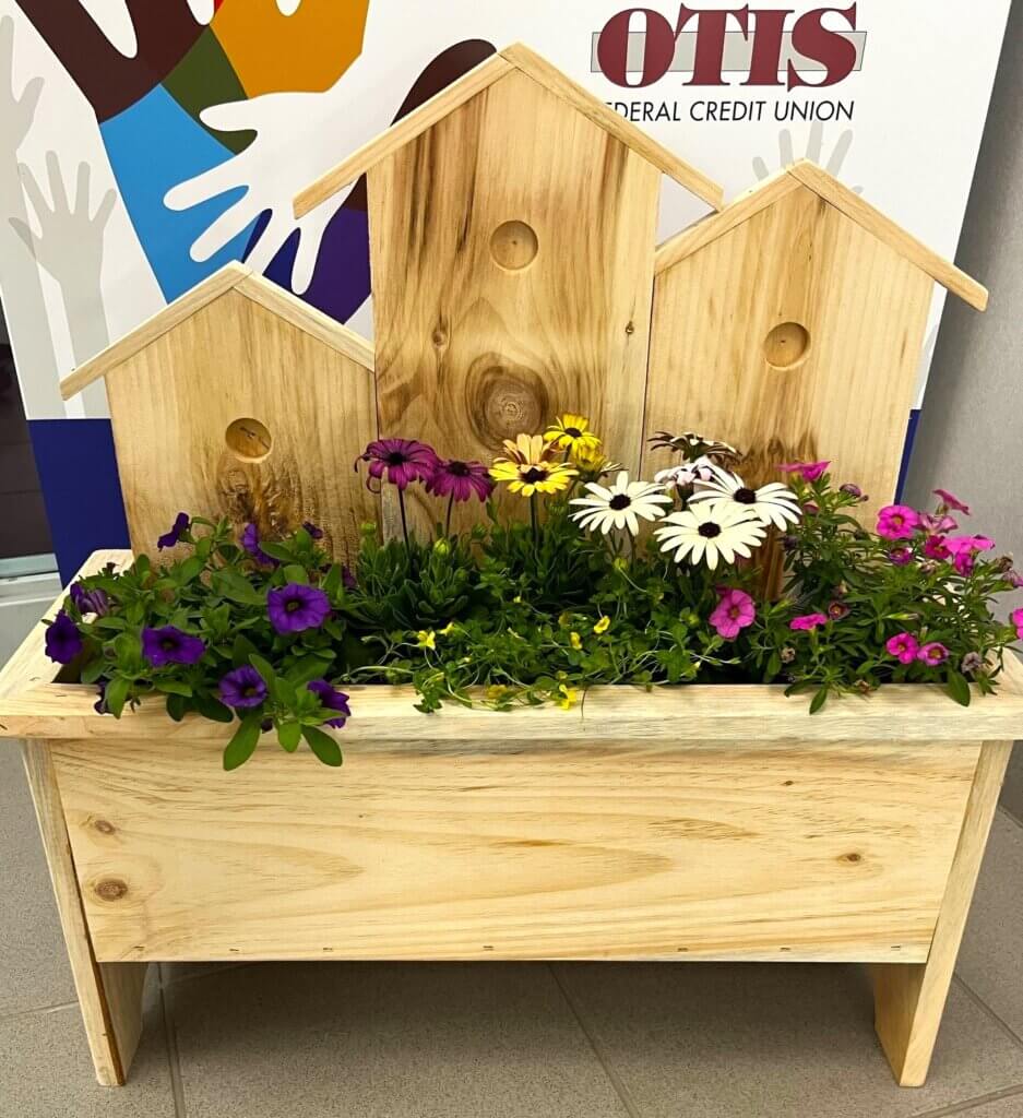 Wooden planter with many flowers.